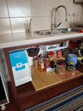 Equipo de ósmosis inversa Infinity: vista angular del sistema de purificación doméstico con carcasa protectora moderna.