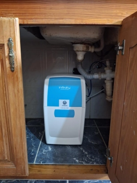 Equipo de ósmosis inversa Infinity ubicado dentro de un mueble de cocina, integrado perfectamente con la toma de agua.